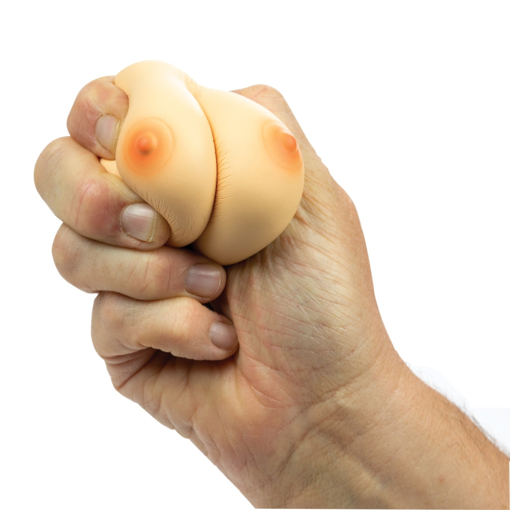 Hand holding a beige breast shaped stress ball with a white background