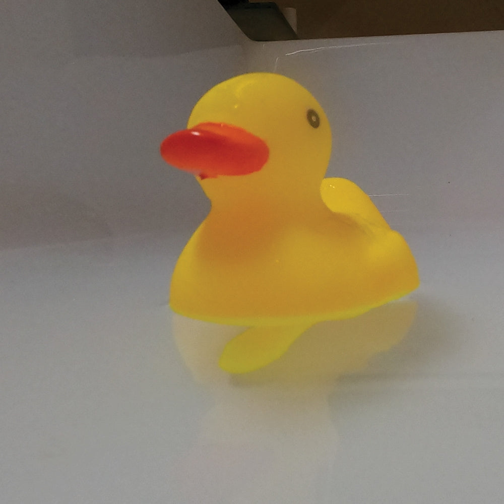 Yellow rubber duck with a red beak on water with a penis underneath